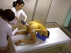 Asian Girl Handcuffed Getting Both Holes Fucked With Toys In Doggy By 2 Masseuses On The Massage Bed