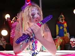Clown Leya Falcon spielt mit einem großen lila Dildo
