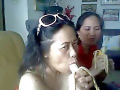 Tailandêsa da senhora madura que mostra seus peitos grandes e sugando a banana