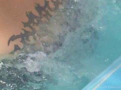 Природная любительская брюнетка пользуется водой в бассейне